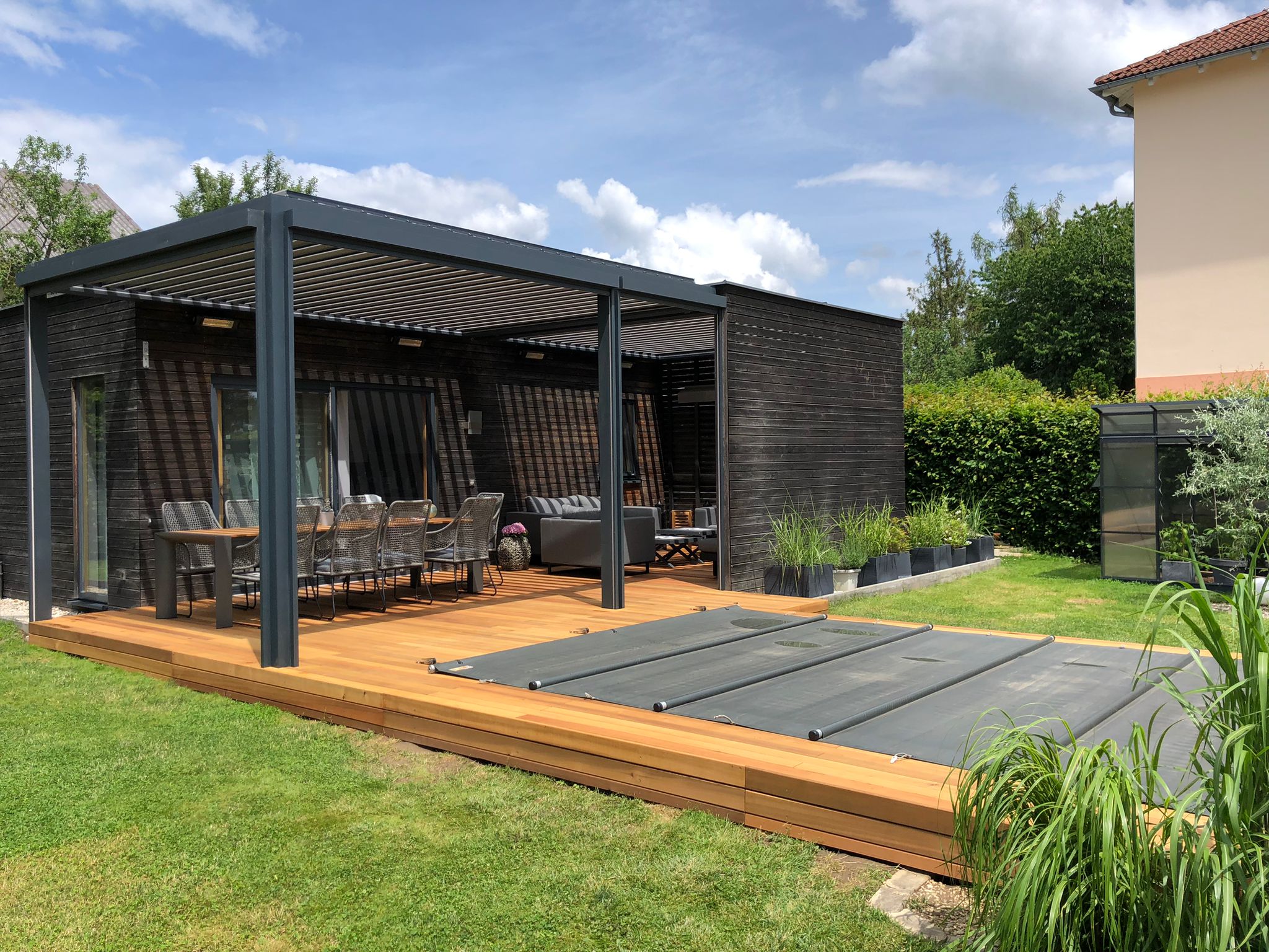 Dachmodul und Wandstruktur einer Lamellenpergola an einem Gartenhaus